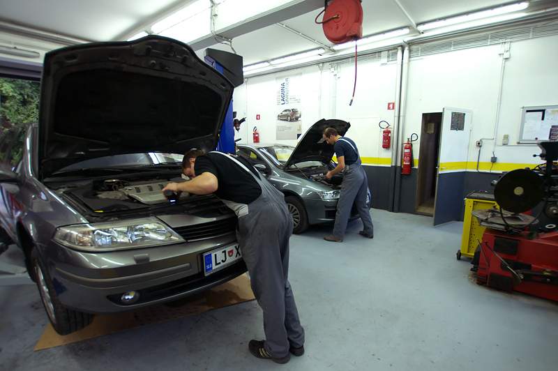 Two mechanics repairing cars